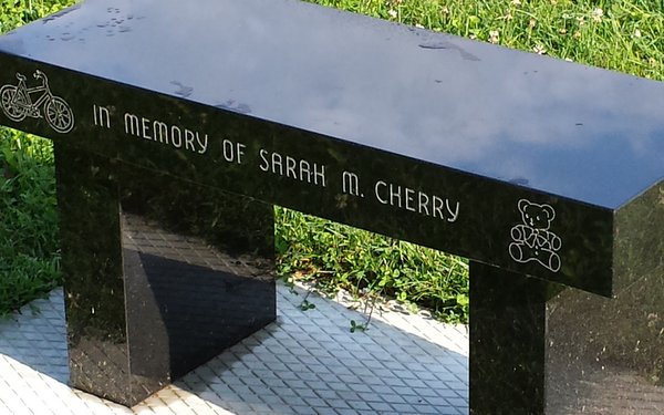Closeup of dedication inscription of memorial bench at the Memorial for Maine Murdered Children in Augusta, ME. 